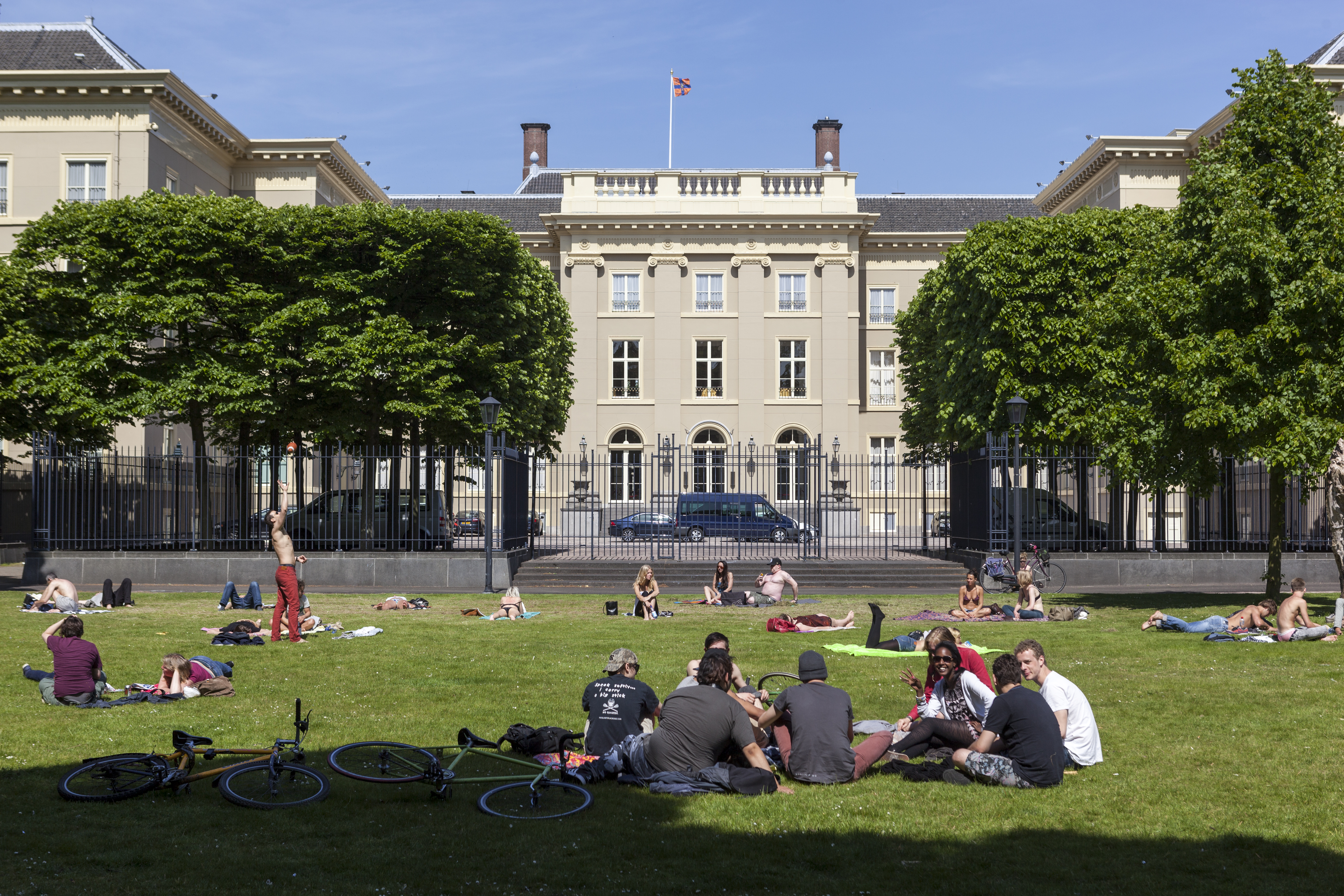 people relaxing in the public Palace Garden behind Noordeinde Palace; The Hague, Netherlands